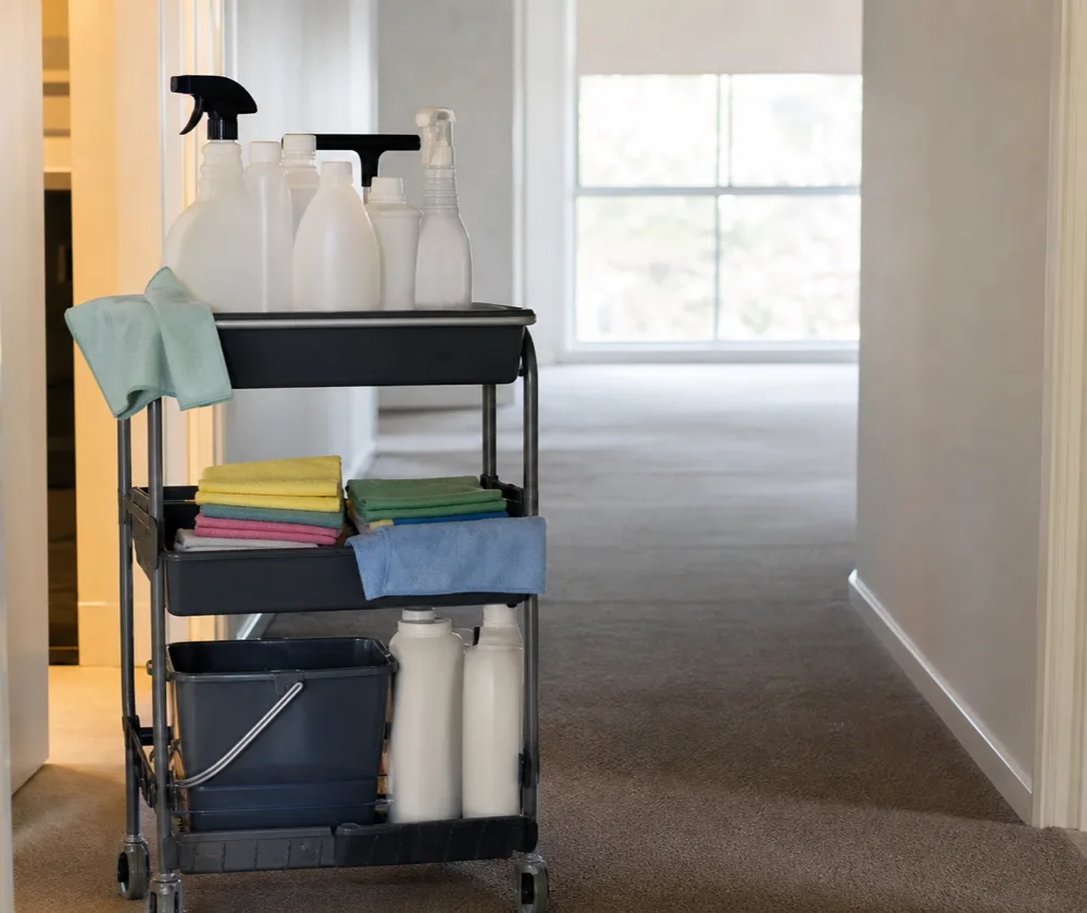 Bond cleaning in Armadale, cleaning trolley with bottles and folded cloths in an empty hallway