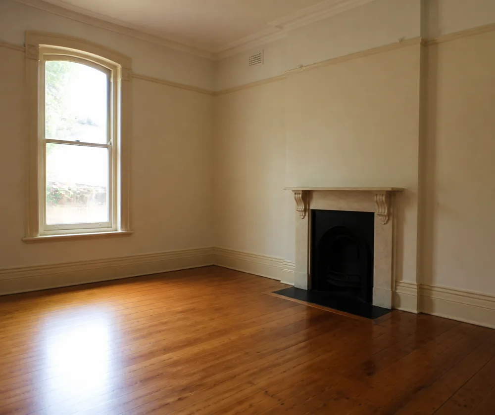 Bond cleaning in Fremantle, empty heritage room with polished floorboards and an original fireplace