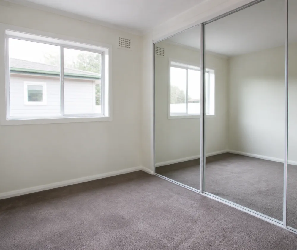 Bond cleaning in Innaloo, empty bedroom with a mirrored built-in robe and freshly vacuumed carpet