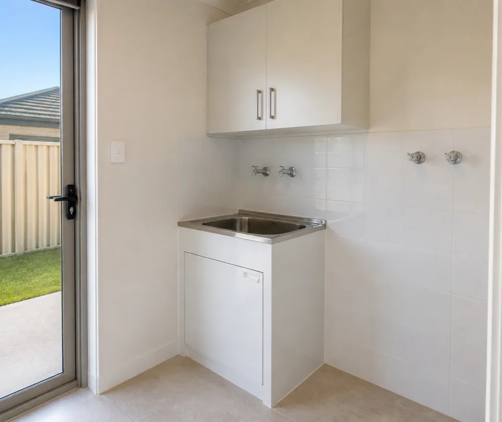 Bond cleaning in Rockingham, empty internal laundry with a clean stainless steel tub