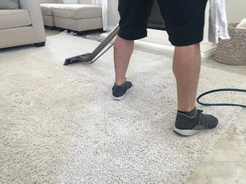 A white rug being cleaned in a living room