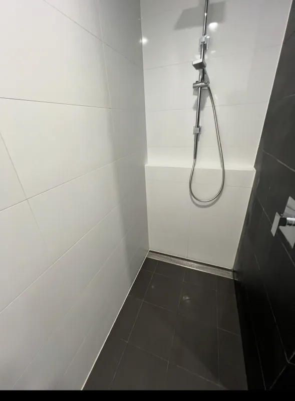 The same shower recess after cleaning, with the wall and floor tiles clear of soap scum
