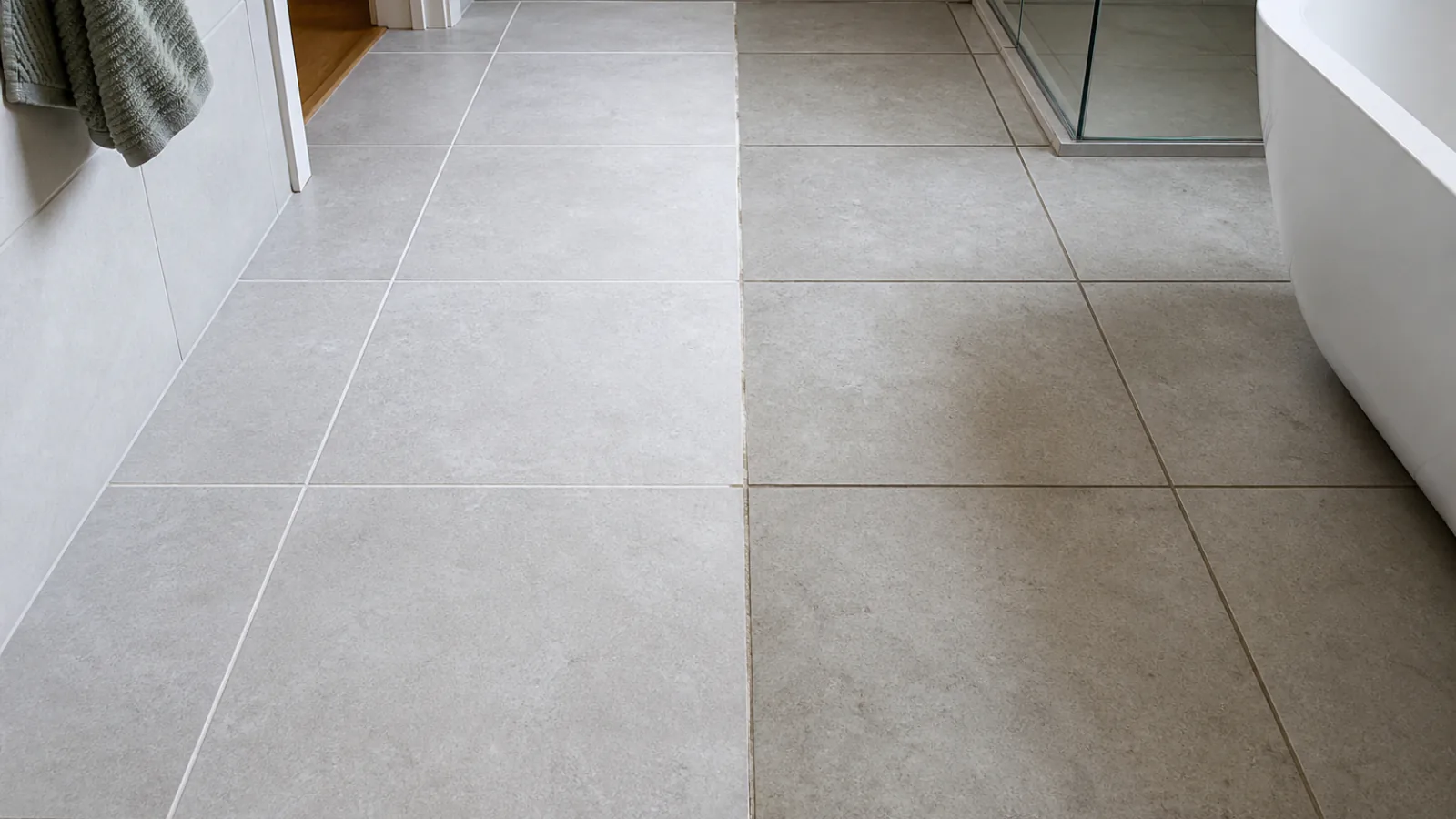 A tiled floor where a cleaned section shows pale grout lines beside an untouched section with darker, discoloured grout