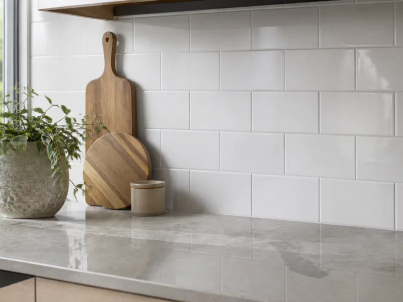 A white subway tile kitchen splashback with clean, uniform grout lines